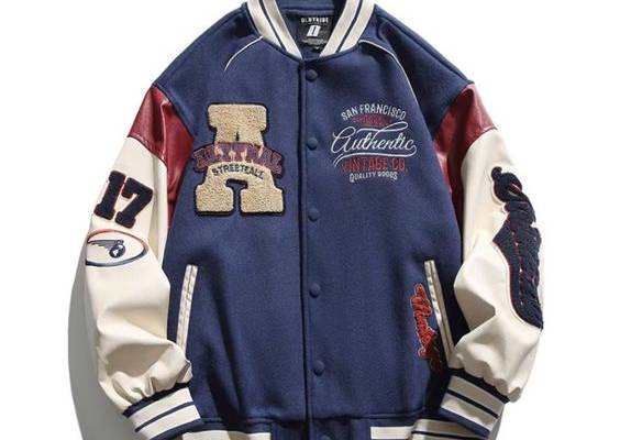 Featuring a unique flocked jacquard pattern, this jacket is sure to turn heads with its intricate and eye-catching design. The contrast detailing on the collar, cuffs, and waistband adds a touch of modern flair, making this jacket a versatile choice for both casual and formal occasions. Features: -92% Polyester, 8% Spandex -Baseball collar -Full button closure -Letter embroidery -Ribbed cuffs and hems -Regular fit -Unisex style