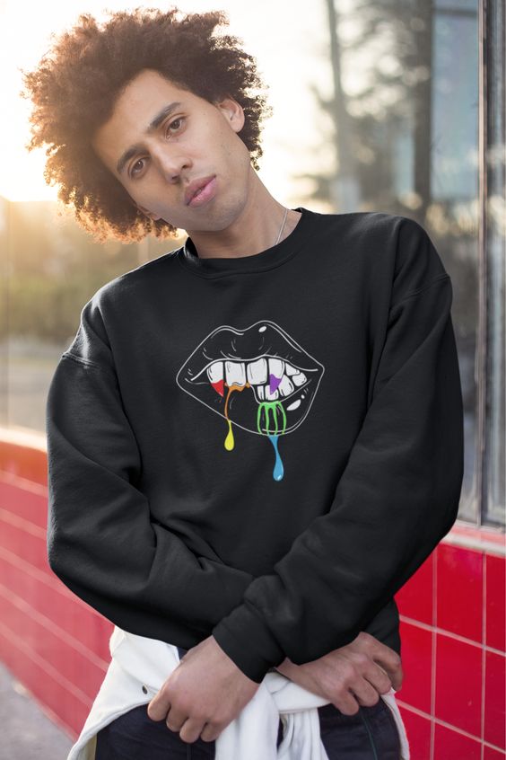 Looking for Halloween sweatshirt ideas? Wear this Halloween sweater to fulfill your cozy Halloween queer outfit! This cute unisex crewneck has a vampire lip design, dripping the pride flag colors! Stop by the shop at kingqueerbiz.etsy.com