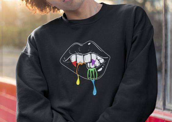 Looking for Halloween sweatshirt ideas? Wear this Halloween sweater to fulfill your cozy Halloween queer outfit! This cute unisex crewneck has a vampire lip design, dripping the pride flag colors! Stop by the shop at kingqueerbiz.etsy.com