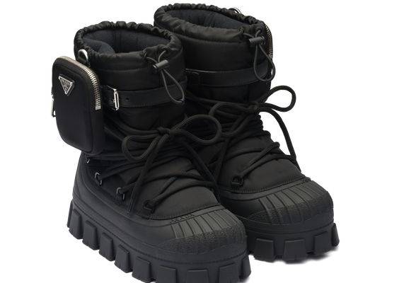 Upper with removable nylon fabric pouch Enameled metal triangle logo Removable padded pile lining Tubular lacing closure 20 cm boot leg Expanded rubber sole with 40 mm shell construction that covers the bottom portion of the upper Lug sole