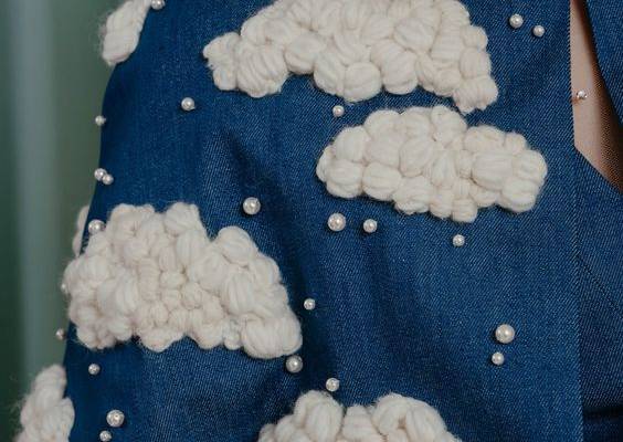Irresistibly playful mid-arm length cape in deep blue denim with fluffy hand-embroidered yarn clouds, embellished with crystal pearls. Composition: 100 % cotton denim Lining: 100 % silk Details: hand embroidery