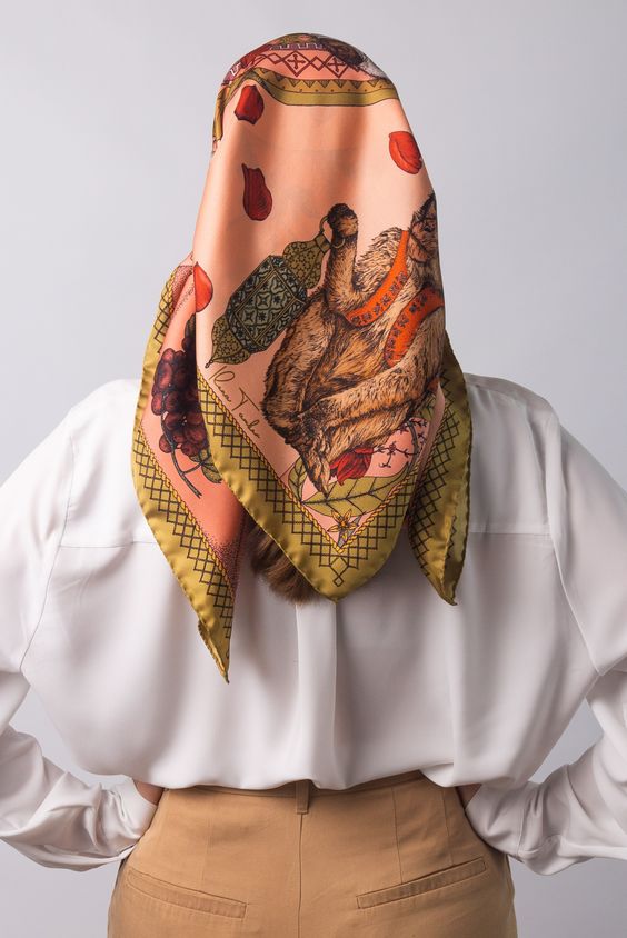 THE MAGIC GIRAFFE DUSKY PINK ART SILK SCARF Creating a mood of transcendence and comfort, the Magic Giraffe silk scarf offers a glimpse into the bounties and splendour that comes with quiet wisdom. With its characteristic patterns and signature features, this silk accessory brings dusky pink hues together with a gentle spray of deep reds and grassy green for an elegant pop of style.