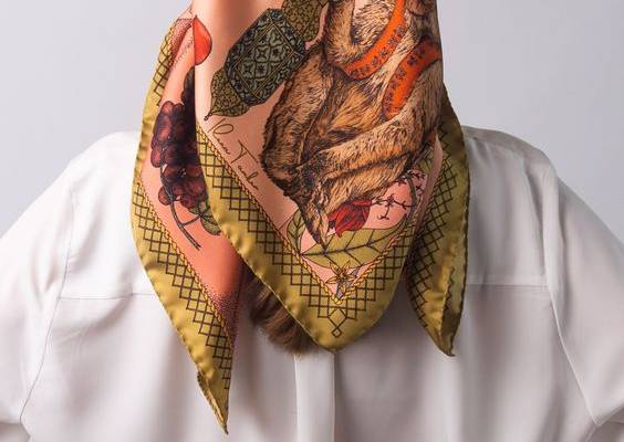 THE MAGIC GIRAFFE DUSKY PINK ART SILK SCARF Creating a mood of transcendence and comfort, the Magic Giraffe silk scarf offers a glimpse into the bounties and splendour that comes with quiet wisdom. With its characteristic patterns and signature features, this silk accessory brings dusky pink hues together with a gentle spray of deep reds and grassy green for an elegant pop of style.