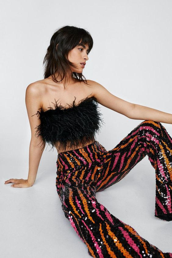 Turn up the heat. Team with a feather crop top and chunky sandals for a night to remember. Sequin Flame Kick Flared Pants Fit and Flare Pants Pull-On Style Long Length All-Over Sequin Embellishments Flame Design Comfortable Woven Lining Model wears size M (US size 6/UK size 10).