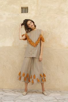 Pom pom adorned knit bombers, wool shag espadrilles and tassel trimmed everything?! Mochi designer Ayah Tabari, once again, is speaking my language with her spring collection. This season, the Palestinian designer has moved on from the motifs of Uzbekistan and onto the warm desert hues and pops of